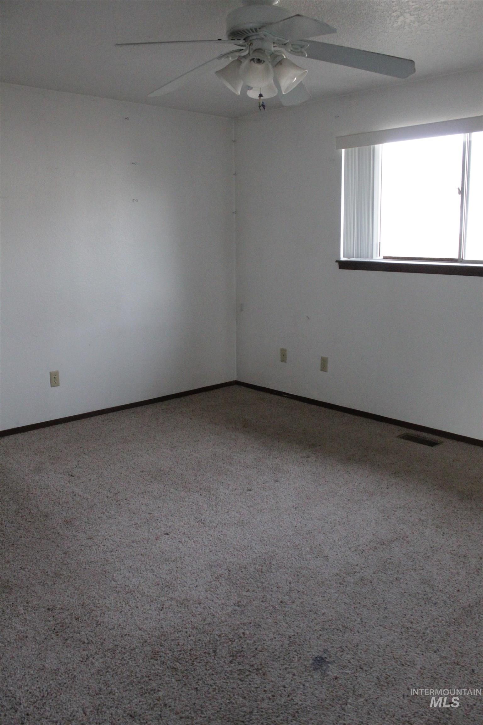 622 East Court Street Weiser, ID 83672 - Photo 15 of 20 Carpeted empty room featuring ceiling fan and baseboards