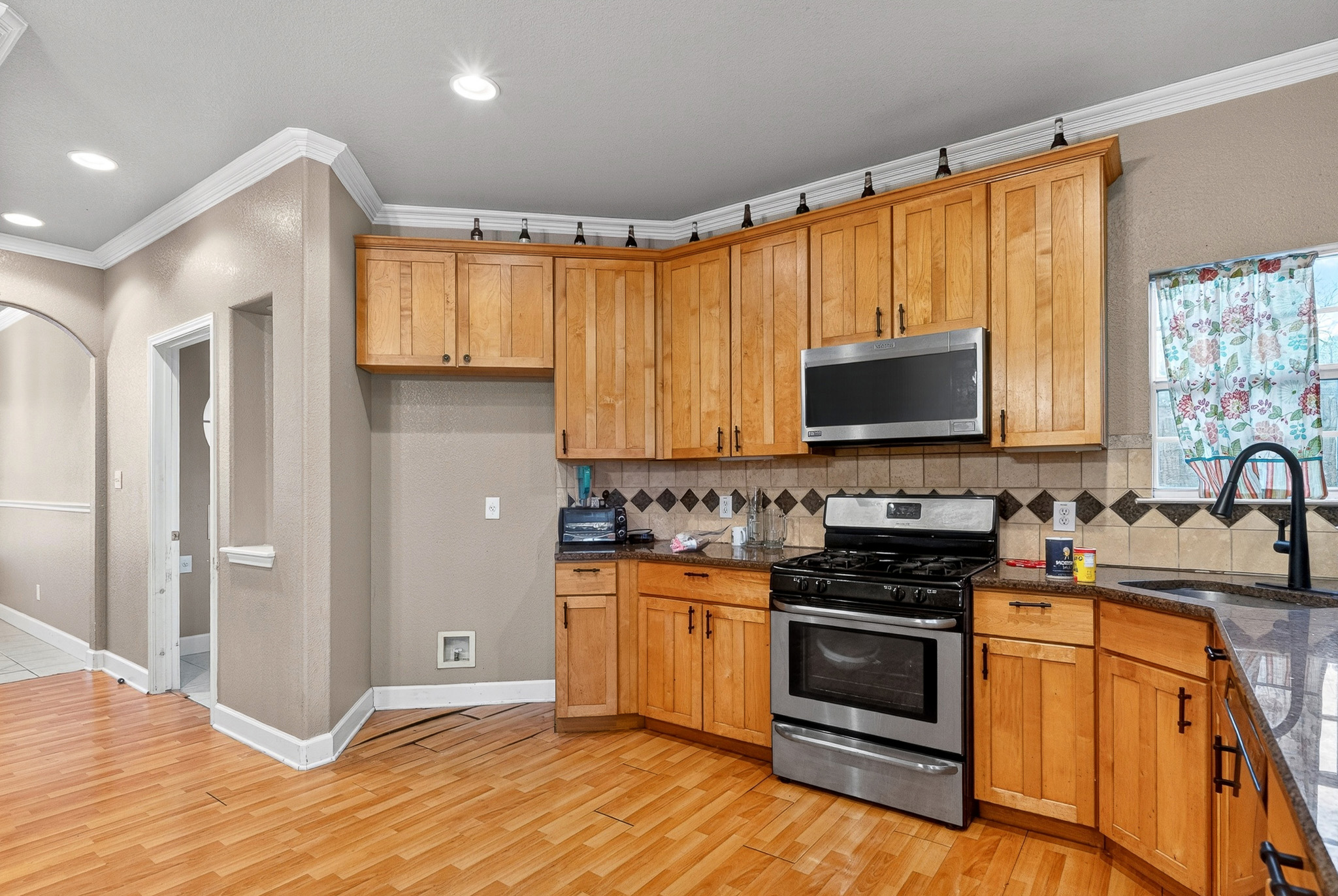 3811 Hawk View Street Round Rock, TX 78665 - Photo 3 of 20 a kitchen with stainless steel appliances a stove a sink and a microwave