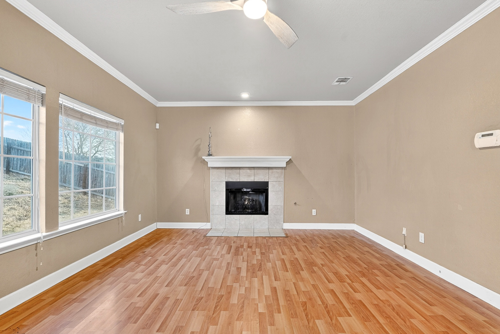 3811 Hawk View Street Round Rock, TX 78665 - Photo 5 of 20 a view of an empty room with wooden floor and a window
