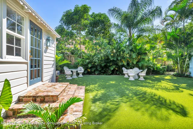 a view of a backyard with table and chairs and potted plants