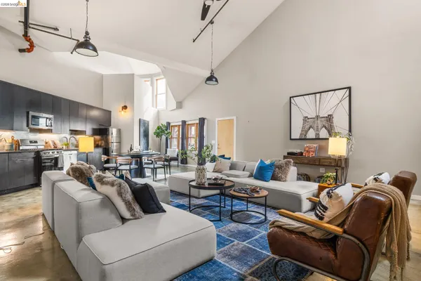 a living room with furniture kitchen view and a chandelier