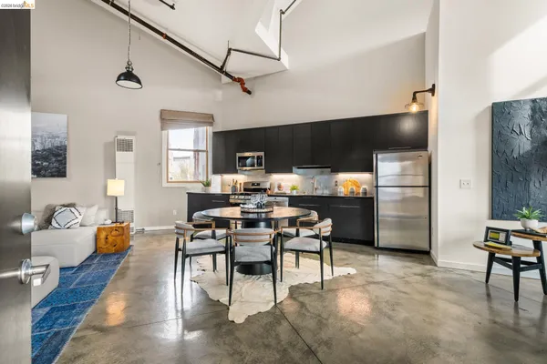 a living room with furniture kitchen view and a wooden floor