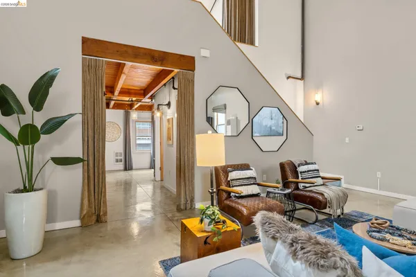 a living room with furniture a mirror and a floor to ceiling window