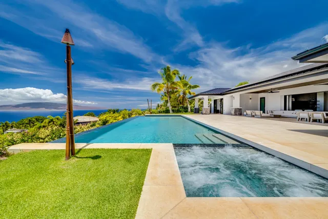 a front view of a house with swimming pool outdoor seating