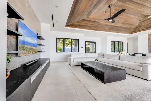 a large living room with stainless steel appliances kitchen island granite countertop furniture and a large window