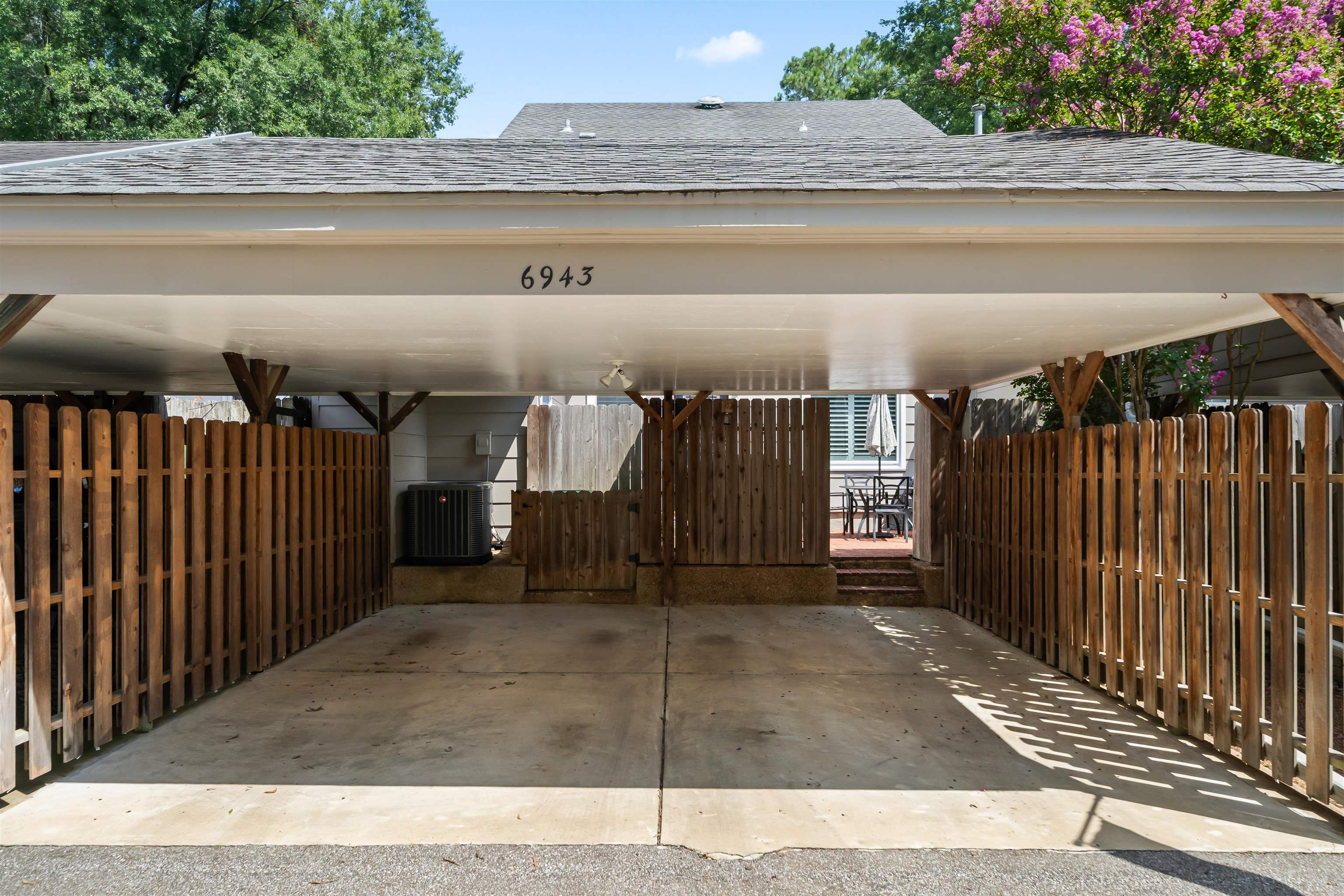 6943 Fords Station Road, Unit 64 Germantown, TN 38138 - Photo 22 of 30 Covered carport with concrete flooring, wood privacy fencing, and direct access to a rear deck