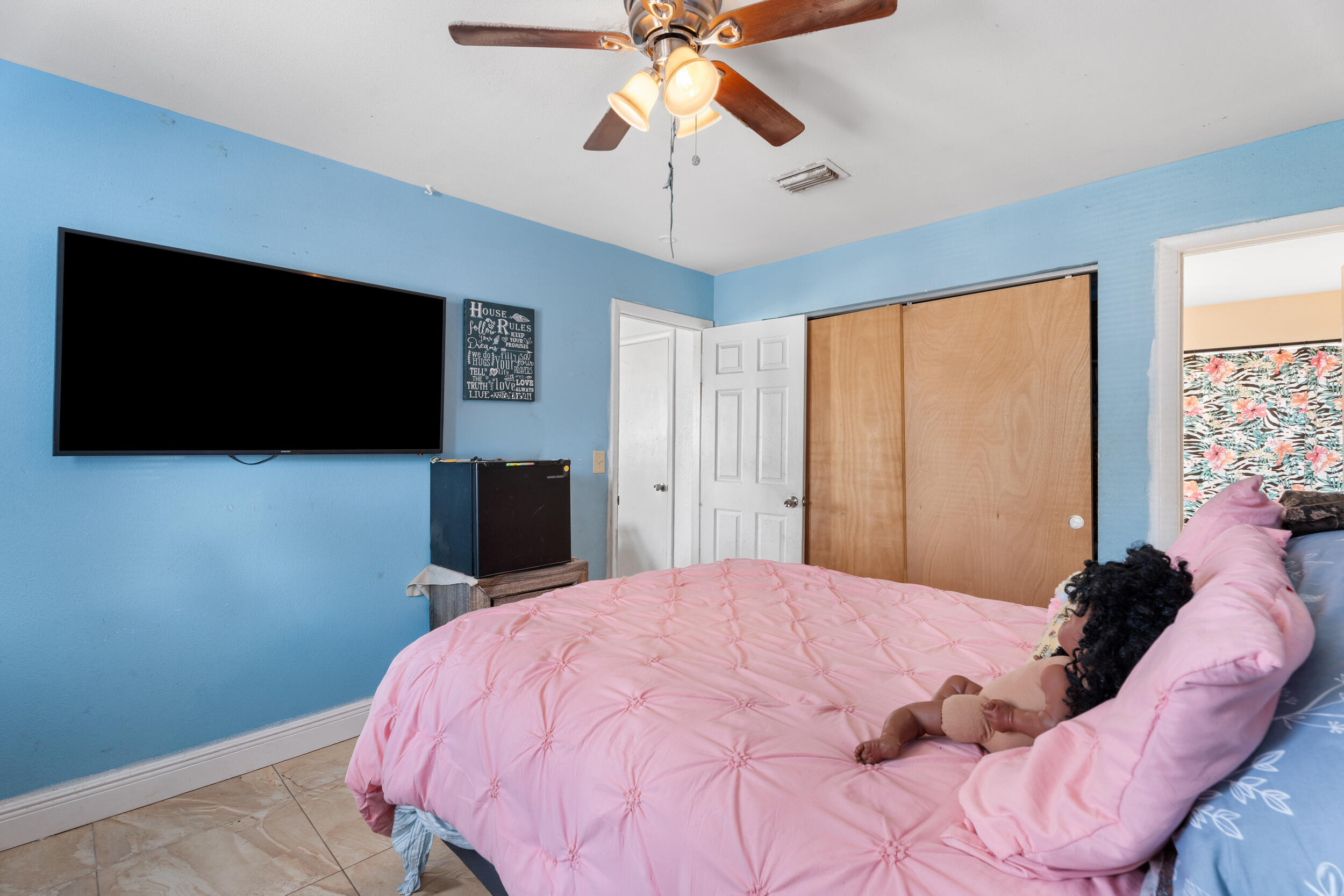 1449 West 35th Street Riviera Beach, FL 33404 - Photo 12 of 28 a bedroom with a bed and a flat screen tv