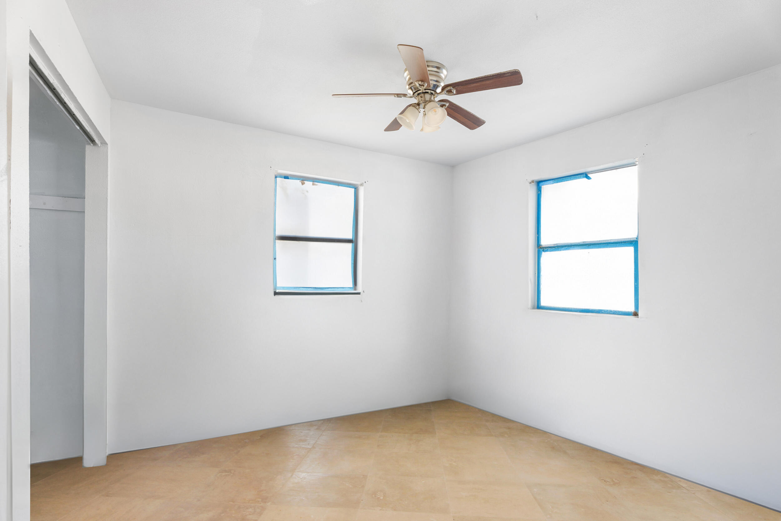 1449 West 35th Street Riviera Beach, FL 33404 - Photo 16 of 28 an empty room with windows and fan