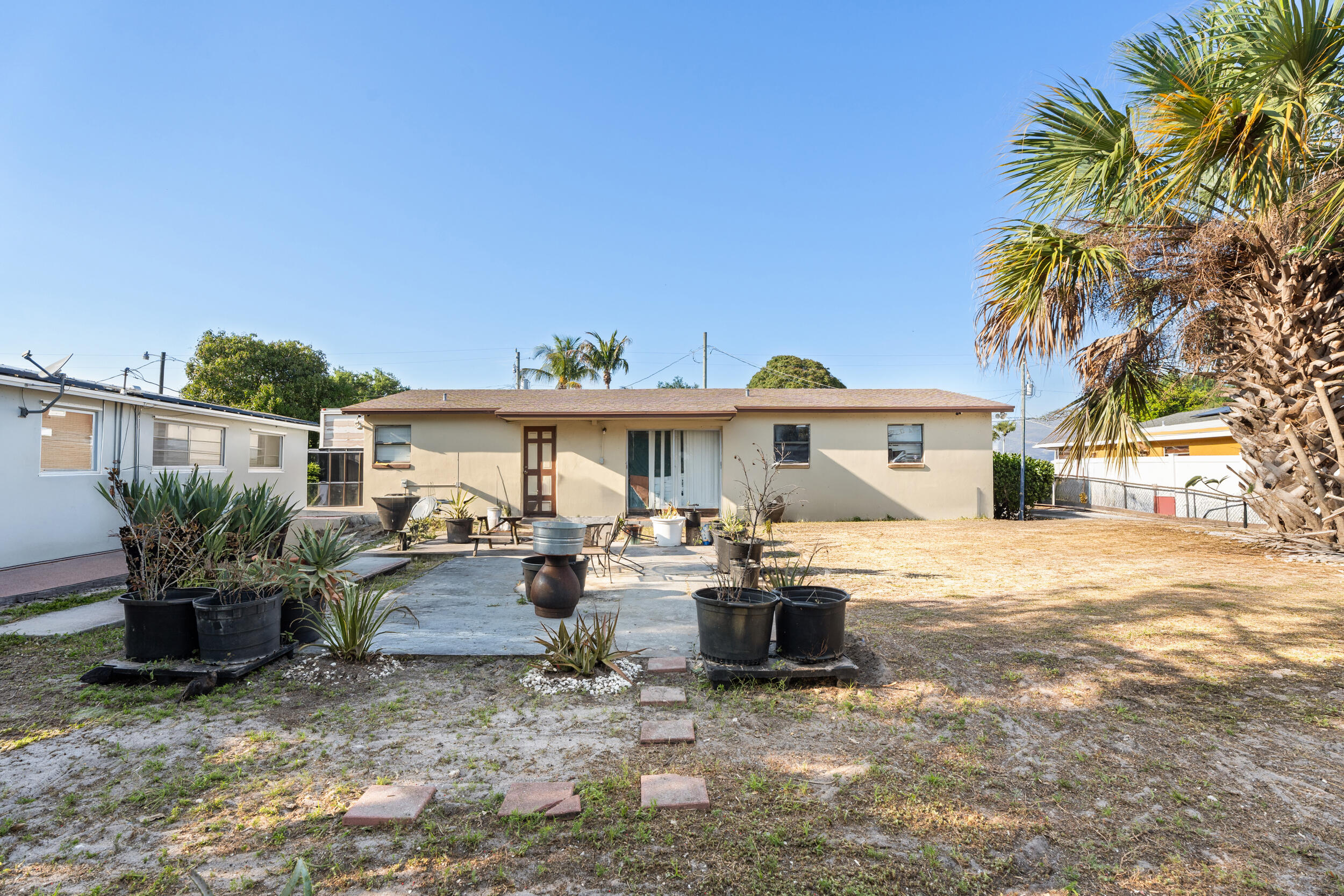 1449 West 35th Street Riviera Beach, FL 33404 - Photo 22 of 28 a view of a house with backyard and sitting area