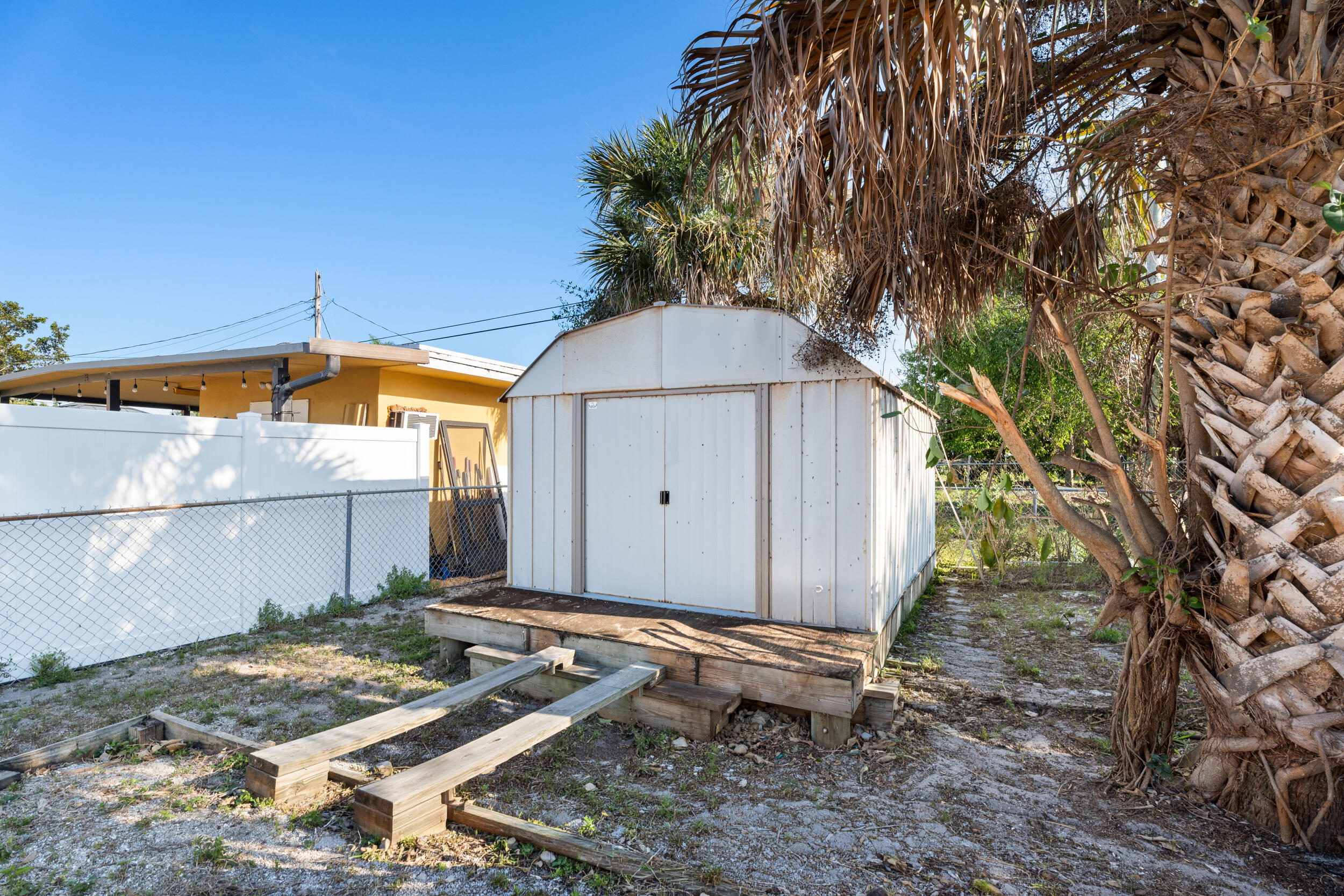 1449 West 35th Street Riviera Beach, FL 33404 - Photo 23 of 28 a backyard of a house with table and chairs under an umbrella
