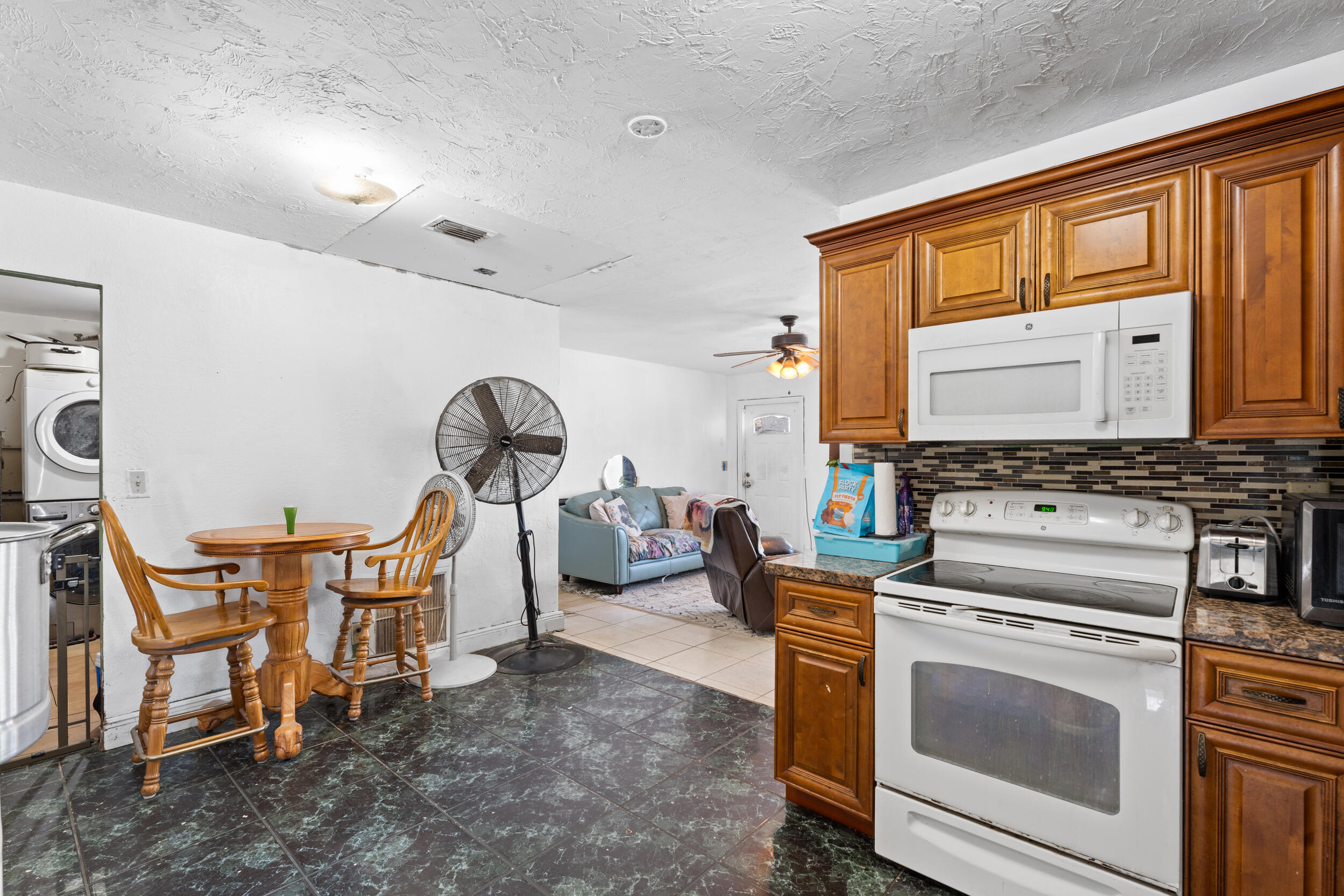 1449 West 35th Street Riviera Beach, FL 33404 - Photo 9 of 28 a view of a kitchen with a sink microwave and cabinets