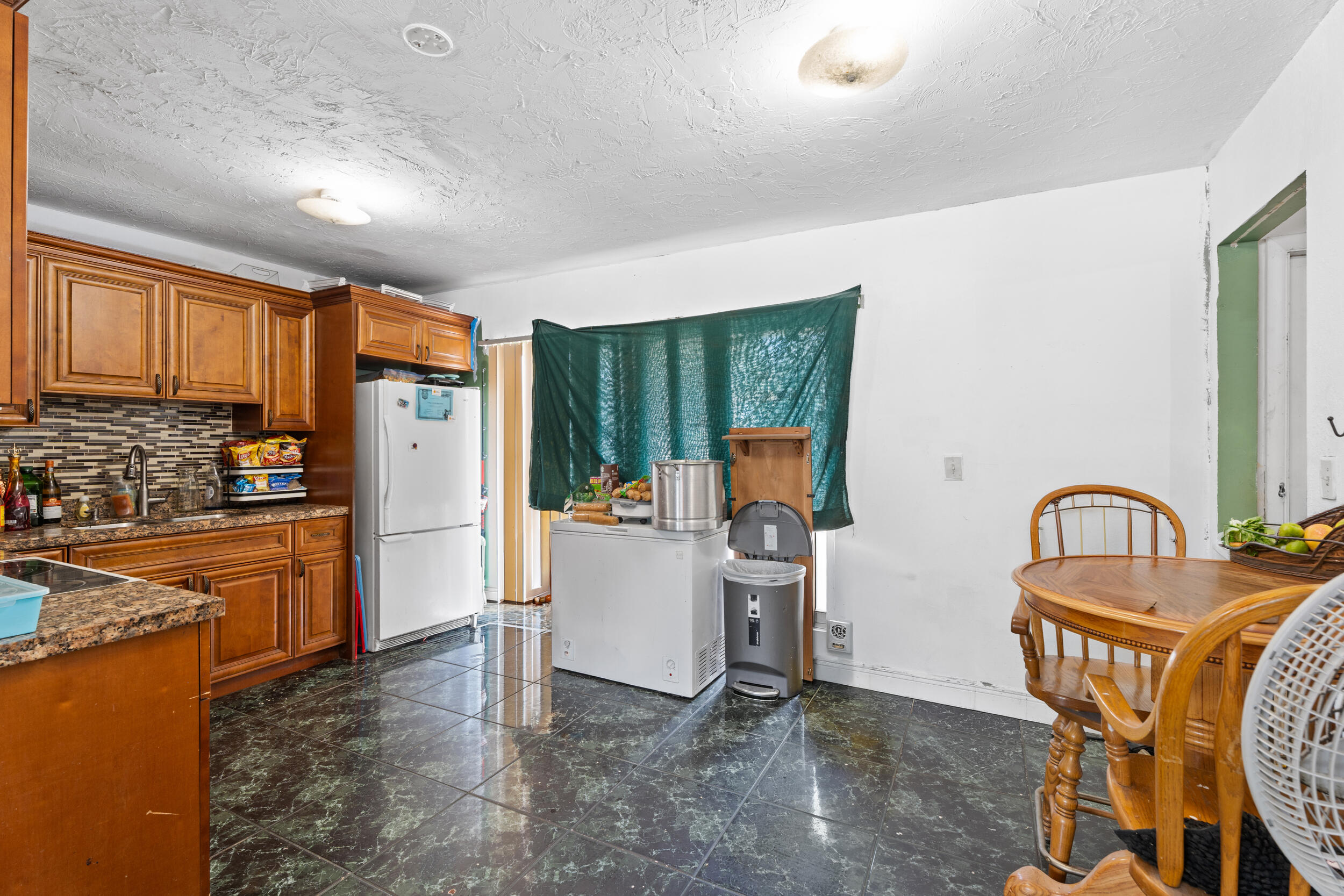 1449 West 35th Street Riviera Beach, FL 33404 - Photo 10 of 28 a kitchen with refrigerator and cabinets