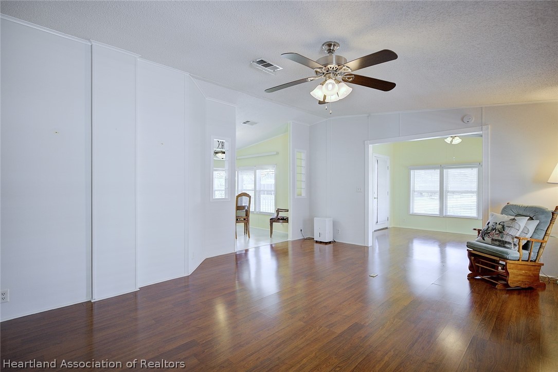 2702 Rodney Street Sebring, FL 33872 - Photo 3 of 33 a view of an empty room with wooden floor and a window