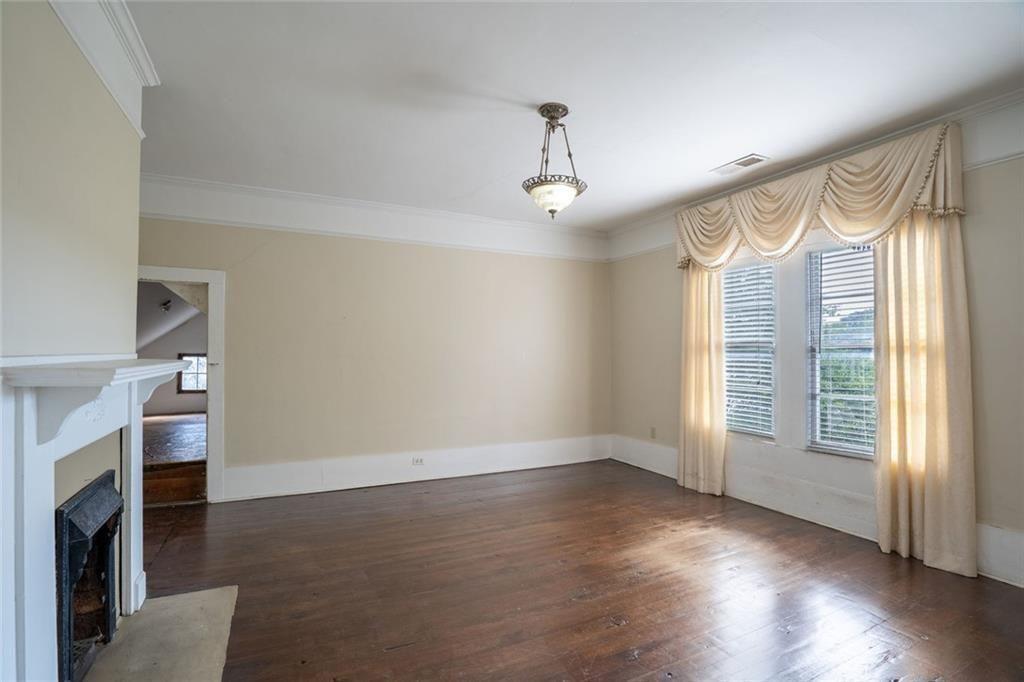 300 Church Street Rockmart, GA 30153 - Photo 39 of 63 an empty room with wooden floor fireplace and windows