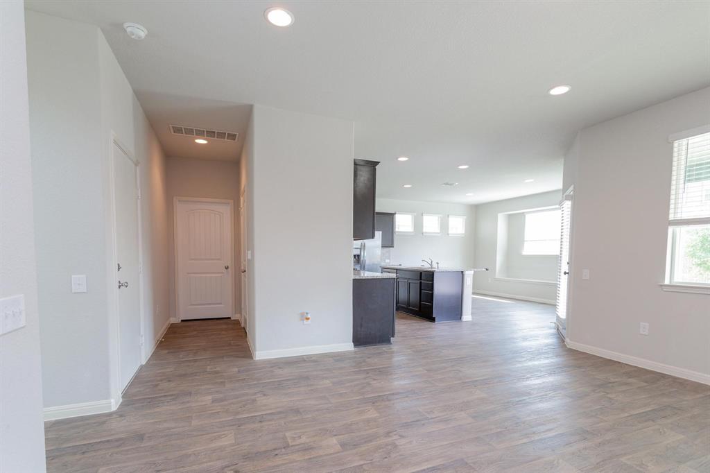 14614 Frankel Loop Pflugerville, TX 78660 - Photo 15 of 15 An open floorplan seamlessly connects the kitchen and living areas, offering effortless movement throughout the home.