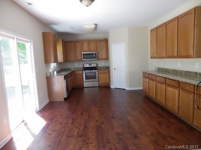 1124 Spicewood Pines Road Fort Mill, SC 29708 - Photo 5 of 16 a kitchen with stainless steel appliances granite countertop a refrigerator a stove top oven a sink dishwasher and wooden floor