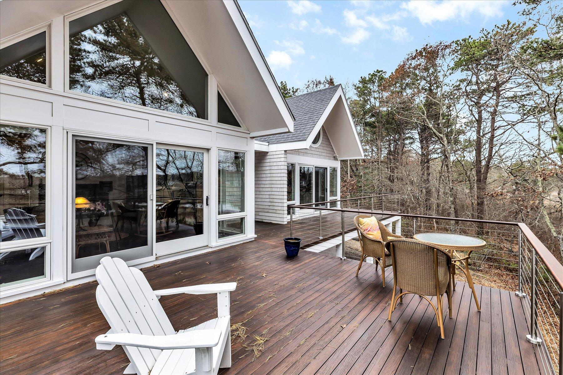 403 Great Oak Road Mashpee, MA 02649 - Photo 40 of 49 a view of a patio with table and chairs with wooden floor and fence