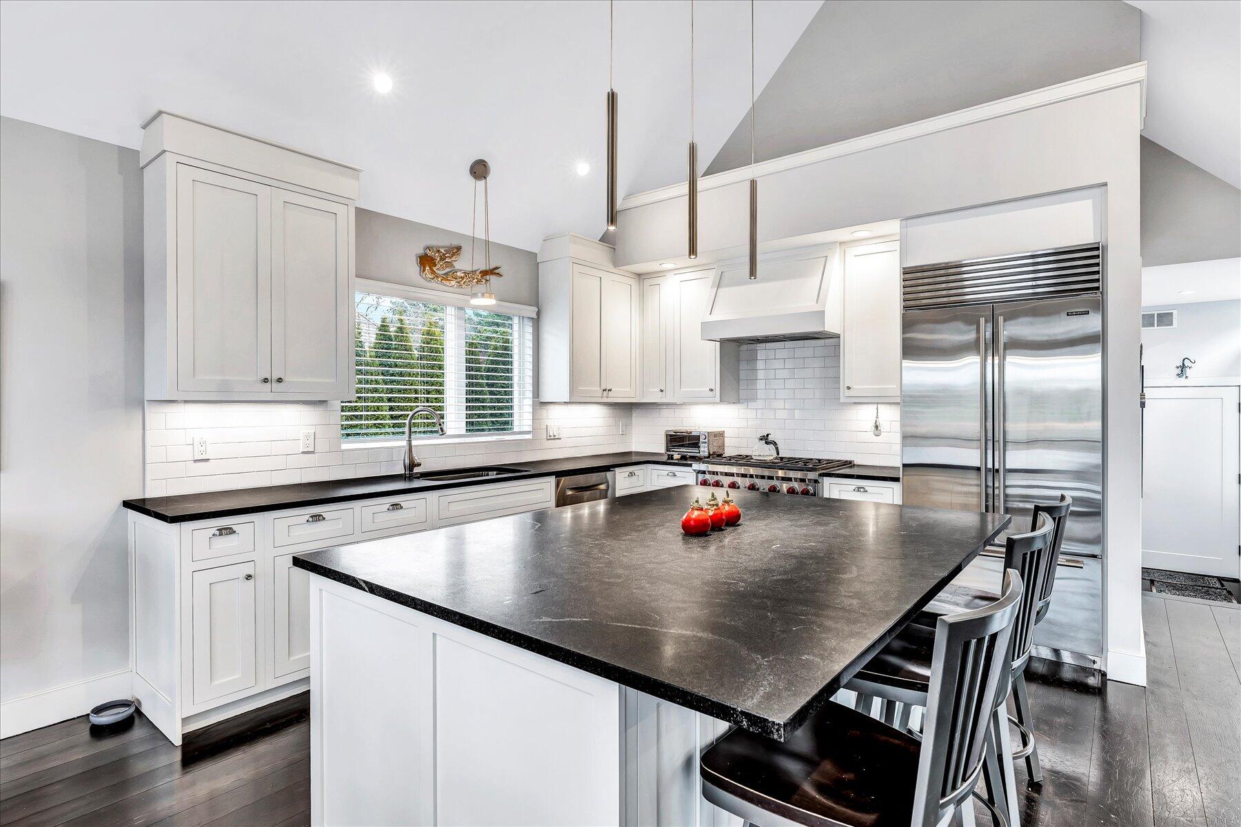 403 Great Oak Road Mashpee, MA 02649 - Photo 10 of 49 a kitchen with kitchen island a table chairs stove and refrigerator