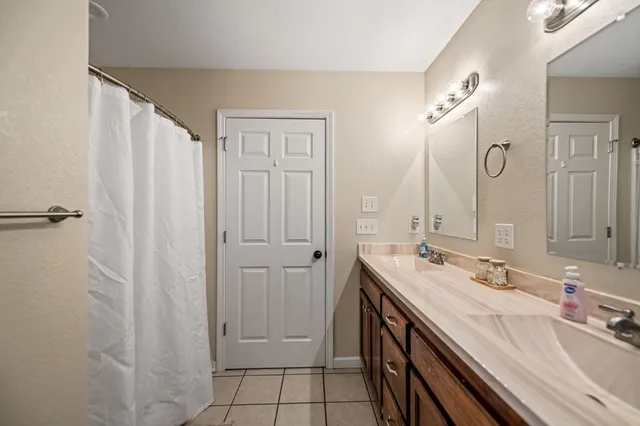 a spacious bathroom with a double vanity sink a mirror and a shower