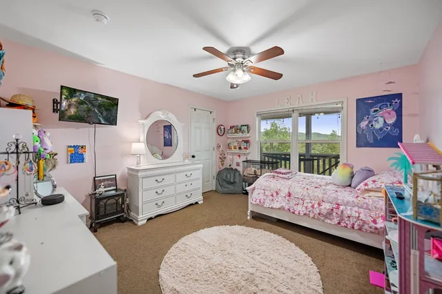 a bedroom with a bed a chandelier and a dresser