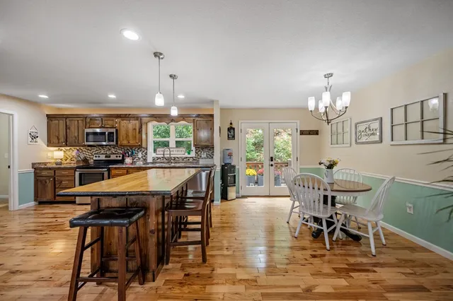 a dining room filled chandelier and wooden floor