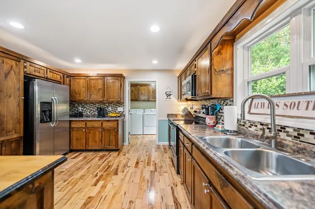 a kitchen with stainless steel appliances granite countertop a sink stove and refrigerator