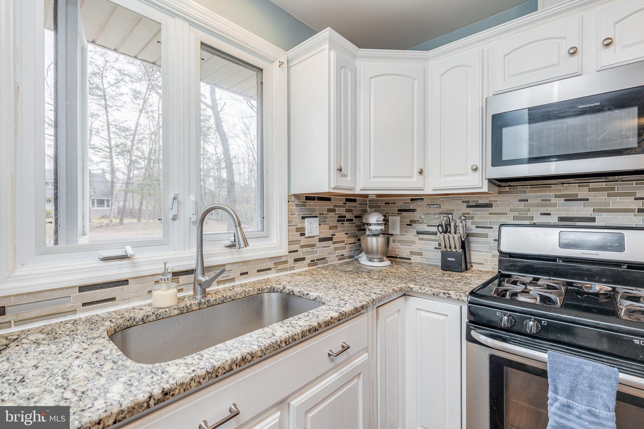 407 Indian Mills Road Shamong, NJ 08088 - Photo 6 of 39 a kitchen with granite countertop a sink stainless steel appliances and white cabinets