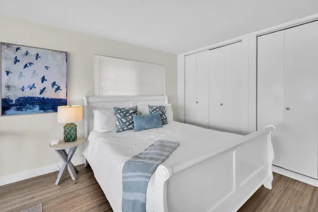 a bedroom with a bed and a painting on the wall