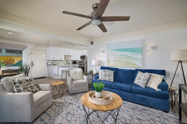 a living room with furniture kitchen view and a window