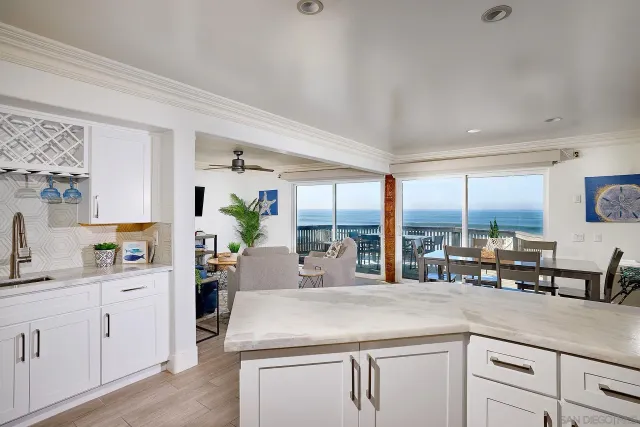 a kitchen with counter top space cabinets and living room view