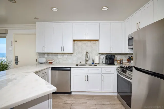 a kitchen with cabinets appliances a sink and a counter top space