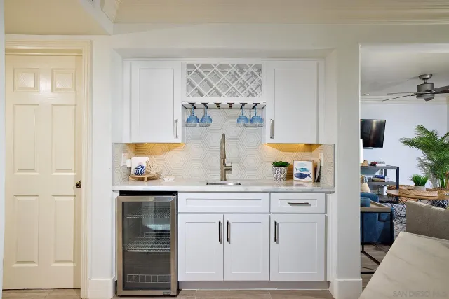 a kitchen with white cabinets and sink