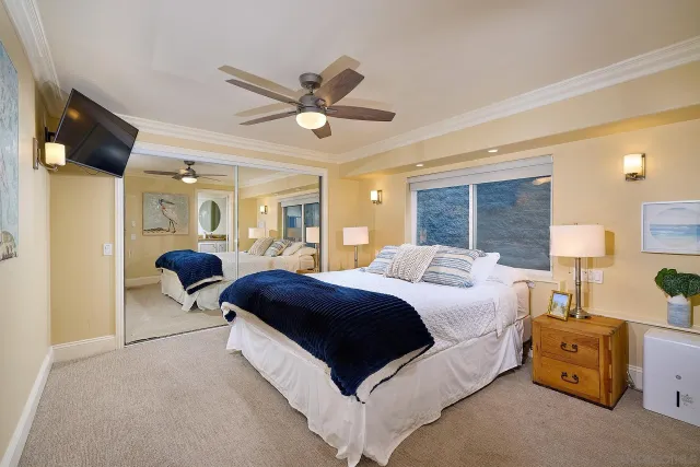 a bedroom with a bed mirror and a window