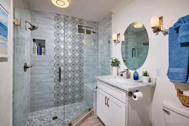 a bathroom with a sink mirror and shower