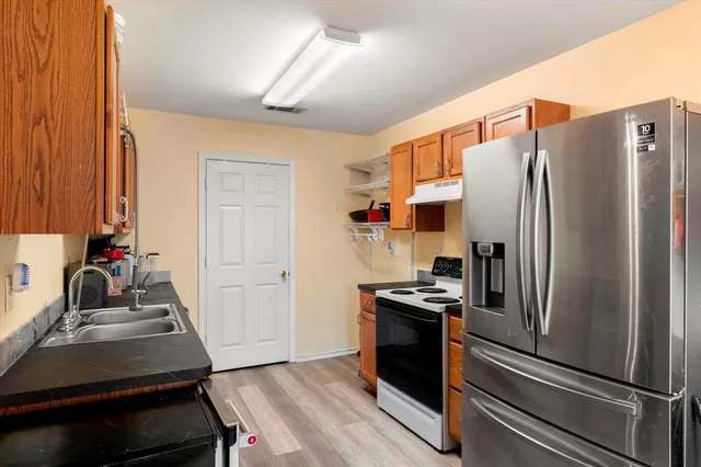 a kitchen with metallic refrigerator and a sink