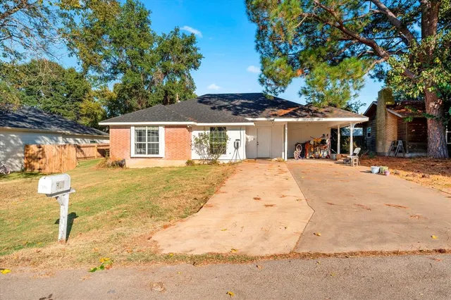 a view of a white house with a large tree