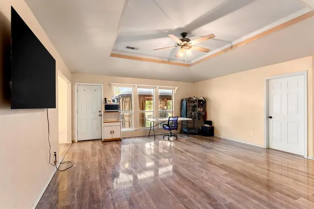 a view of a livingroom with furniture wooden floor a flat screen tv and staircase