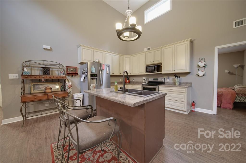 3579 Harmony Road Catawba, SC 29704 - Photo 13 of 48 a kitchen with stainless steel appliances granite countertop a stove top oven a refrigerator a sink and dishwasher a oven with wooden floor