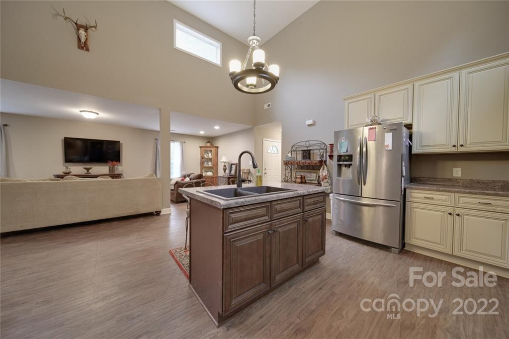 3579 Harmony Road Catawba, SC 29704 - Photo 10 of 48 a kitchen with stainless steel appliances granite countertop a stove top oven a refrigerator a kitchen island with couches and cabinets
