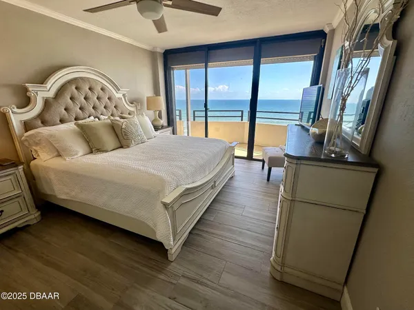 a large bedroom with a bed and a flat tv screen