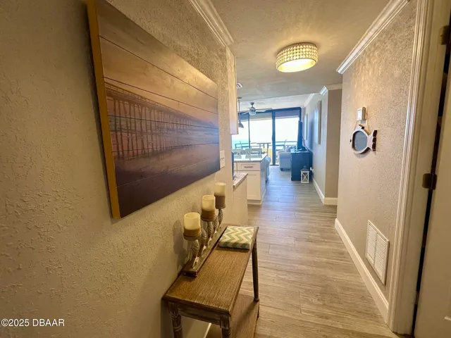 a hallway with wooden floor stairs and furniture