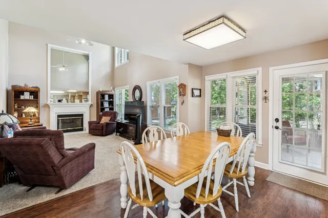 a dining room with furniture large windows and a fireplace