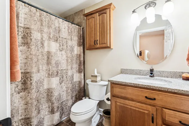 a bathroom with a granite countertop sink mirror vanity and toilet