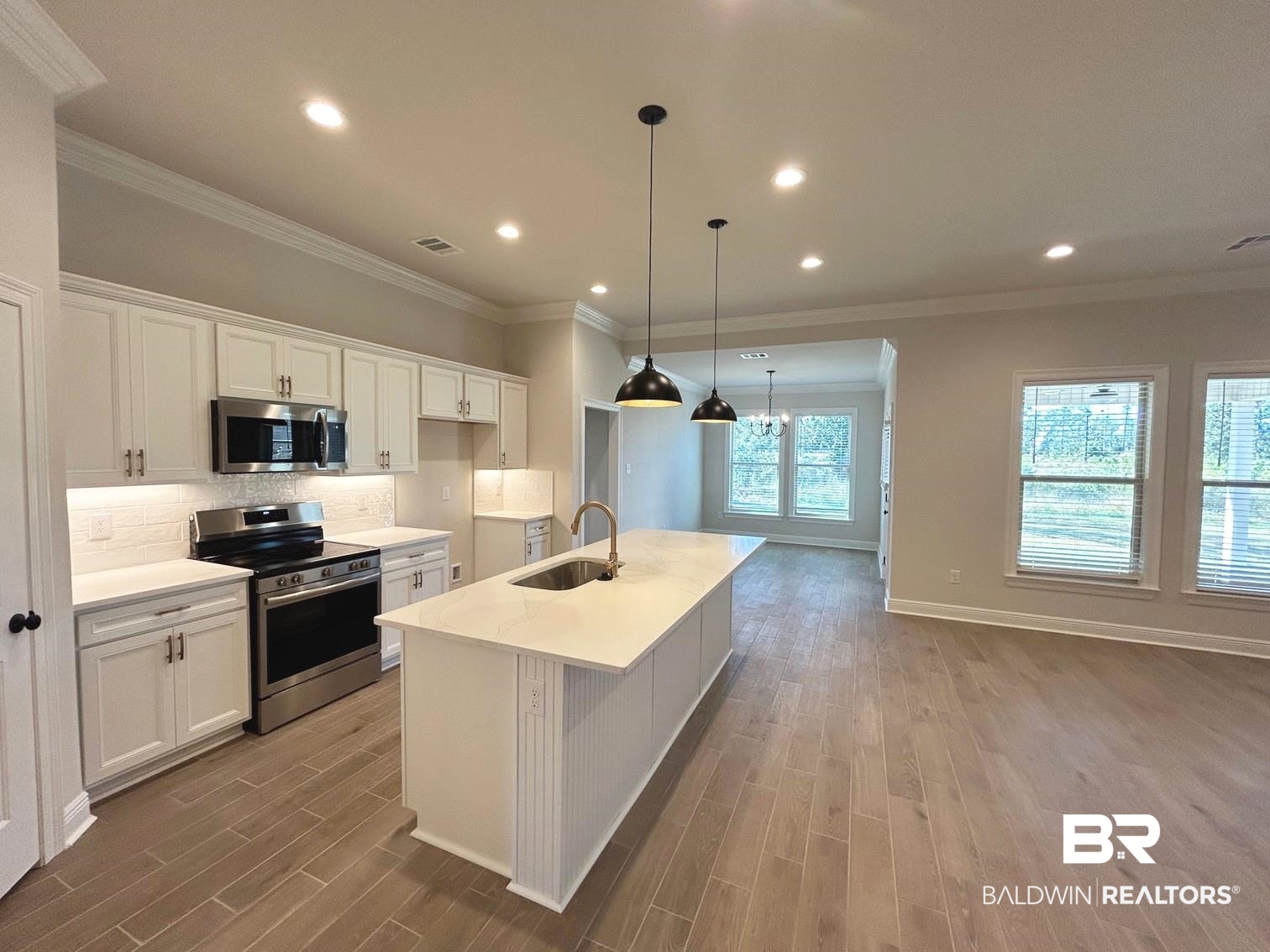 872 Sumter Loop Foley, AL 36535 - Photo 3 of 18 Kitchen with sink, light wood-type flooring, stainless steel appliances, white cabinets, and a center island with sink