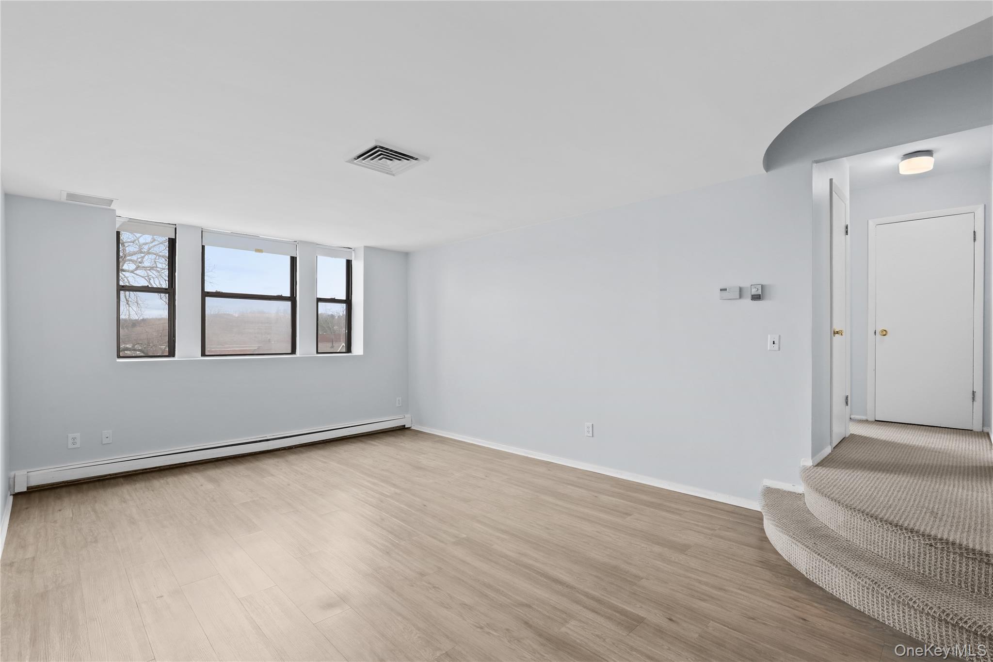 60 Kensico Road, Unit 22 Thornwood, NY 10594 - Photo 3 of 14 a view of an empty room with wooden floor and a window