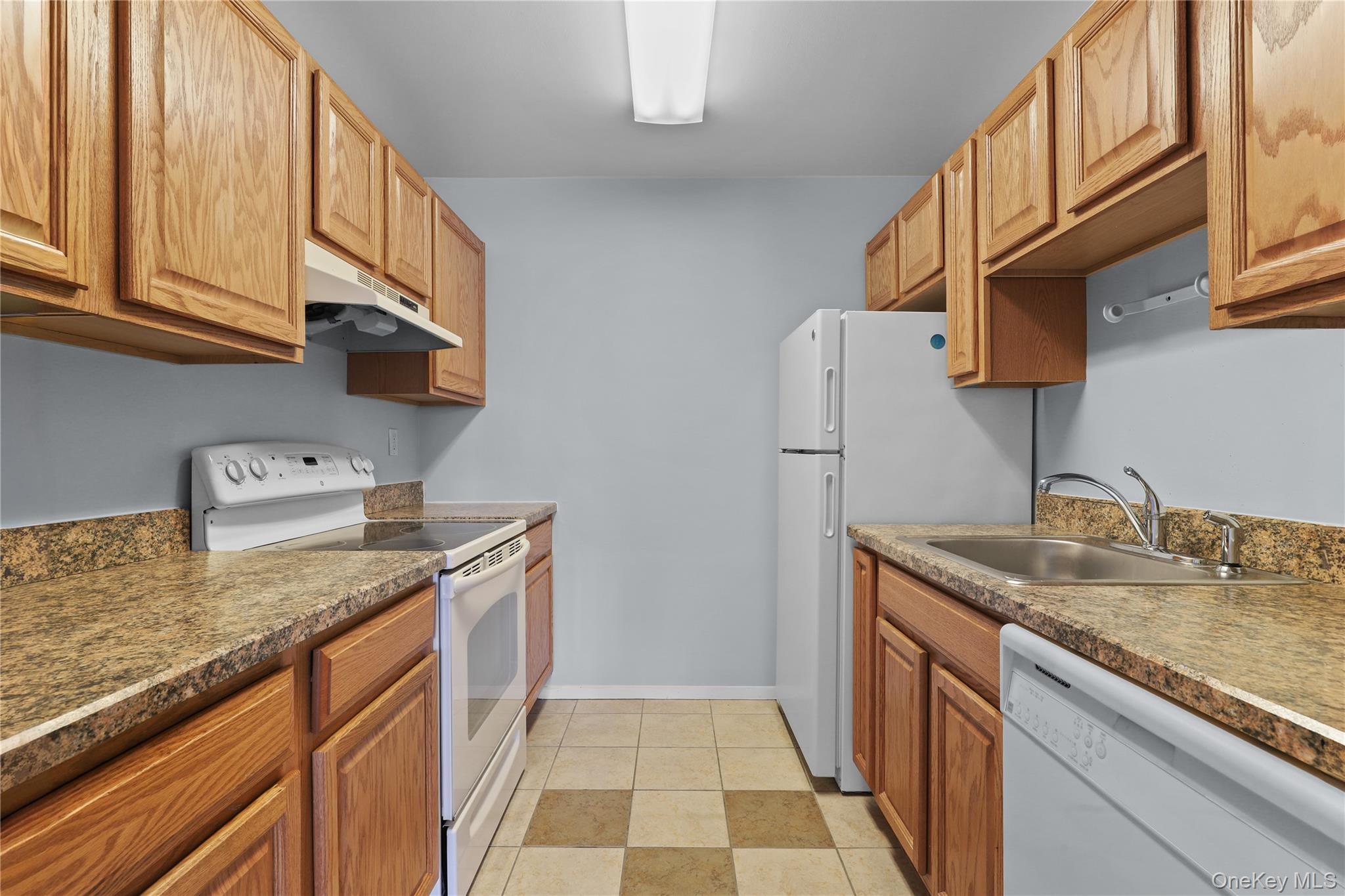 60 Kensico Road, Unit 22 Thornwood, NY 10594 - Photo 6 of 14 a kitchen with stainless steel appliances granite countertop a sink stove and refrigerator