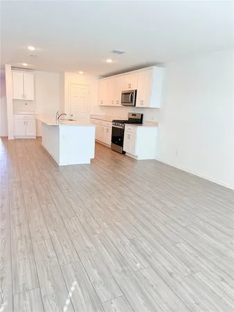 a view of kitchen with wooden floor and electronic appliances