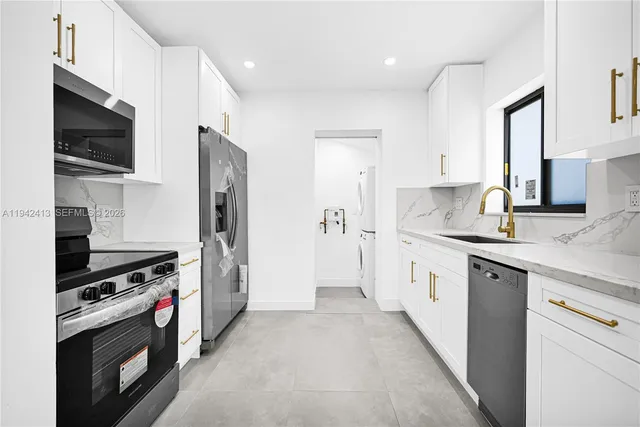 a kitchen with stainless steel appliances a stove a sink and a refrigerator