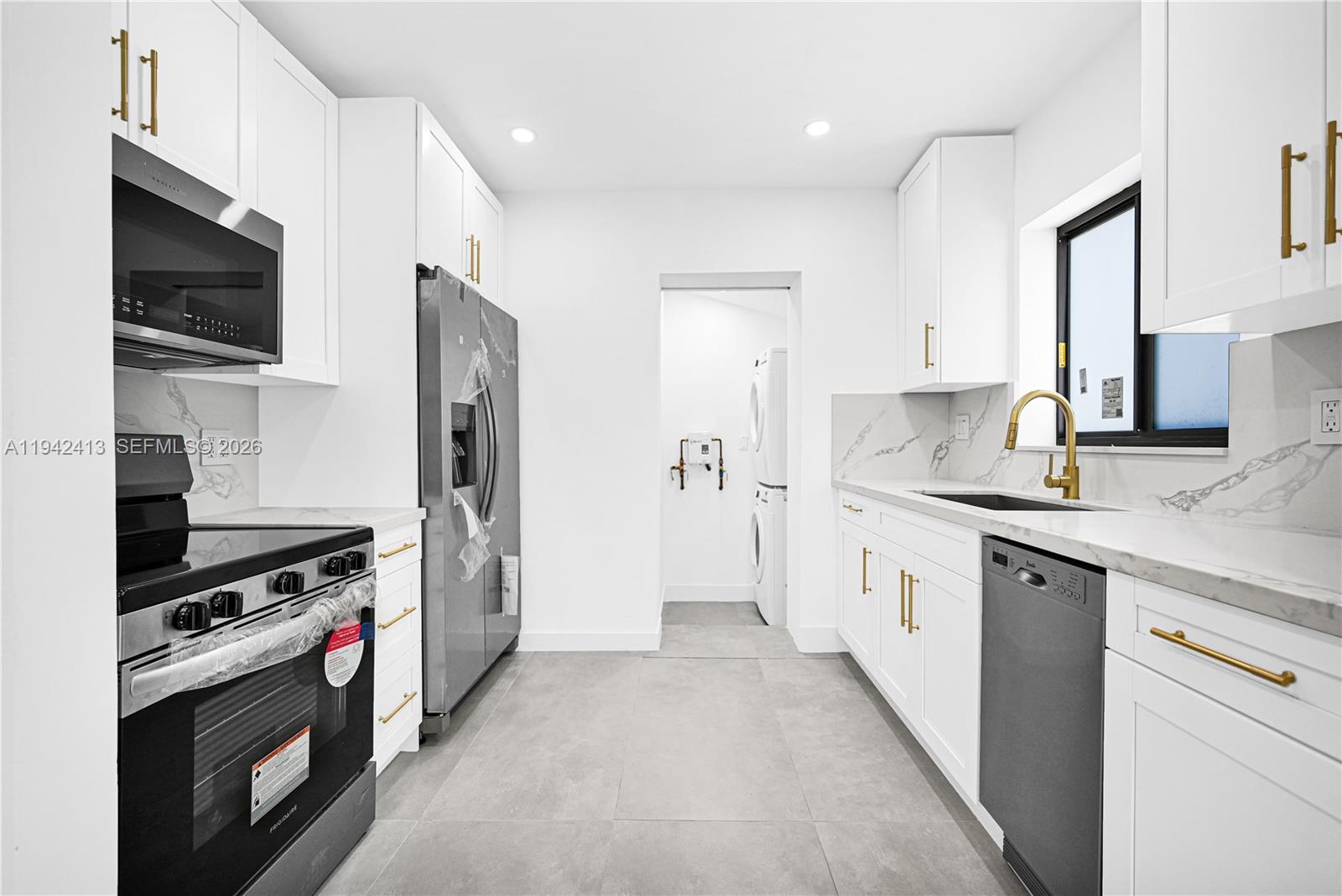 2261 Southwest 26th Street Miami, FL 33133 - Photo 3 of 12 a kitchen with stainless steel appliances a stove a sink and a refrigerator