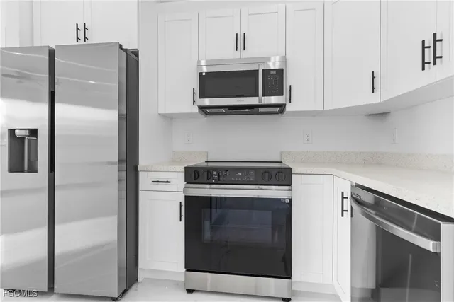 a kitchen with stainless steel appliances white cabinets a stove and a refrigerator